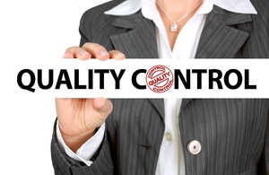 Businesswoman holding 'quality control' sign