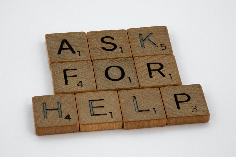 Wooden letter tiles spelling 'ask for help'