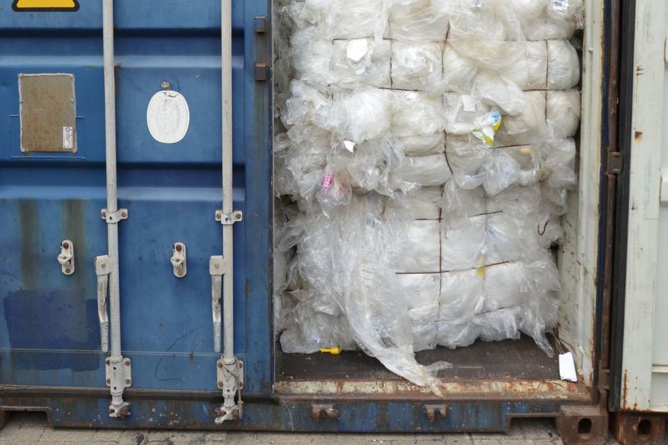 The door of a large container opened, showing the container full of waste