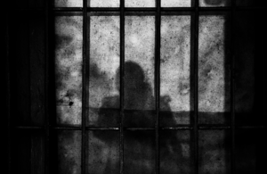 Shadow of prisoner behind bars