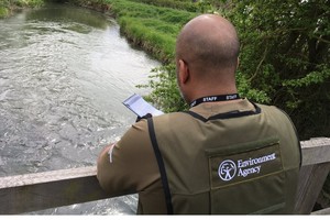 Сотрудник Агентства по охране окружающей среды стоял на мосту над рекой.