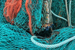 A pile of blue and orange fishing nets, and thick rope