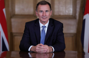 Chancellor of the Exchequer Jeremy Hunt sitting at a table looking at the camera