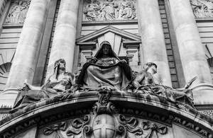 Statue of Recording Angel flanked by Fortitude and Truth above main entrance to the Old Bailey.
