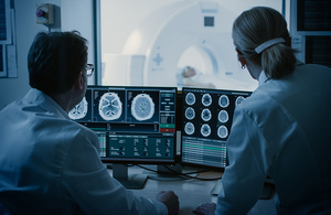 Two radiologists looking at CT scans on a computer screen