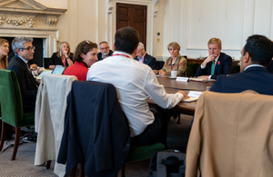 Members of the National Cyber Advisory Board sitting around a table and having a meeting.