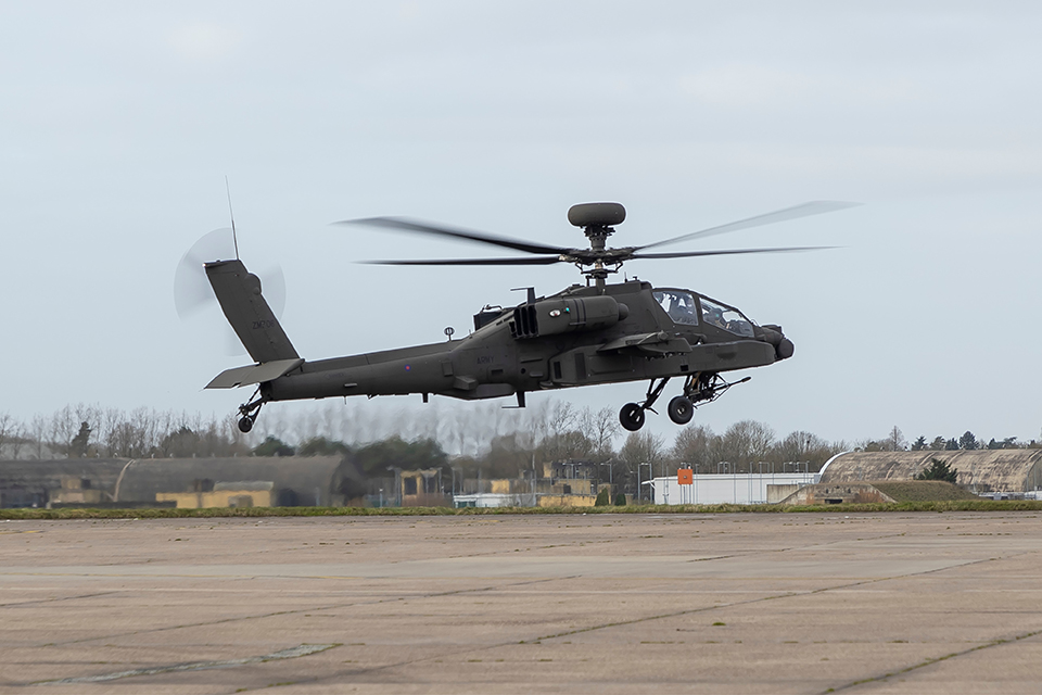A black apache helicopter taking off 