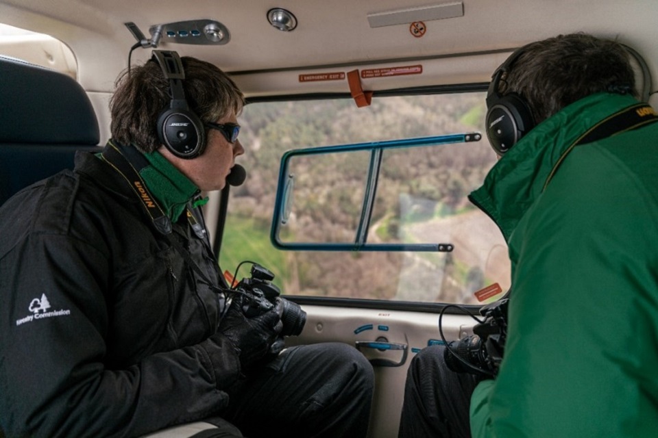 Aerial surveillance carried out by the Forestry Commission, shown as being undertaken via helicopter and using cameras to take pictures.
