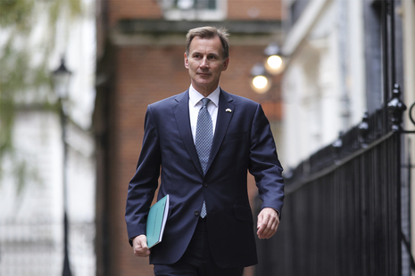 Chancellor Jeremy Hunt walking with the Autumn Statement 2022 in hand