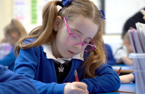 Child holding pencil in classroom