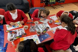 Five schoolchildren making drawings for the Bromford flood defence scheme mural
