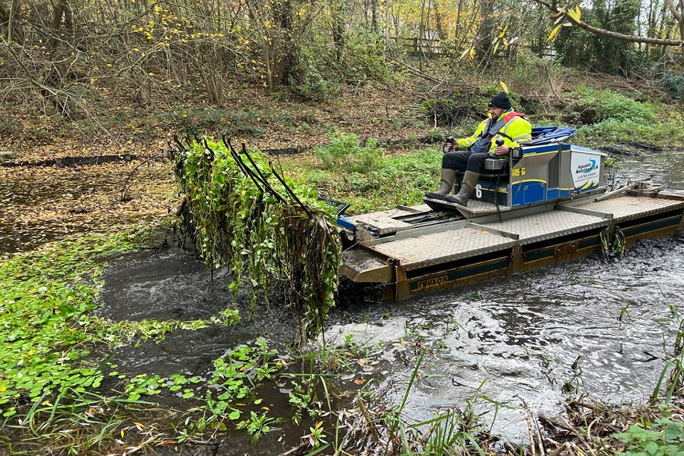 A man operating a Truxor machine to scoop up floating pennywort