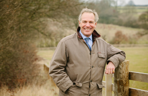 William Worsley leaning on a fence in a field