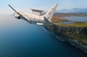 Royal Air force aircraft flying in the air. Overlooking a cliff and the sea.