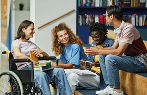 Teens sit together in a library , chatting.