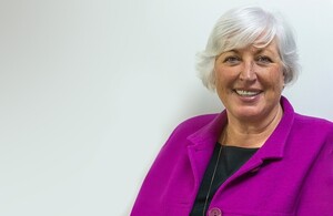 A woman in a purple jacket smiling