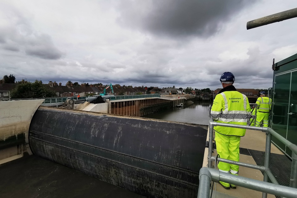 An Environment Agency worker in personal protective equipment stood looking out at the river from the Boston Barrier.