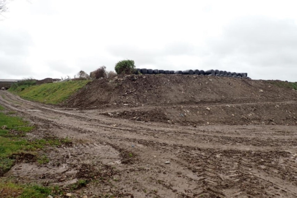 A large mound of soil dominates the photo
