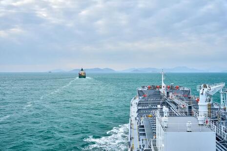 View from a cargo ship's bow sailing off the coast of Vietnam, two cargo ships sail in the distance