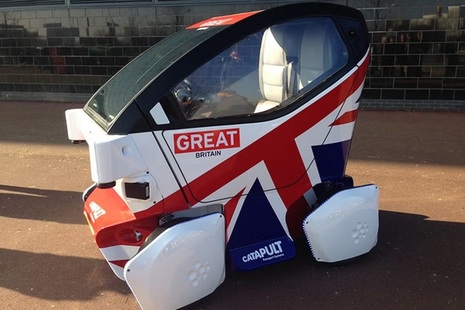 A small driverless car decorated with the United Kingdom flag.