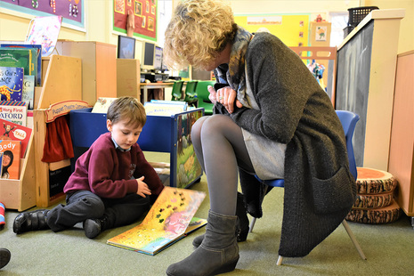 Reception teacher with pupil, reading and counting