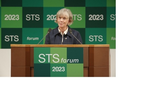 Photo of Government Chief Scientific Adviser Dame Angela McLean speaking at STS Forum in Japan. She is standing against a backdrop of squares in different shades of green with "STS 2023" written on them.