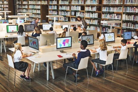 Школьники работают за компьютерами в библиотеке.  Кредит Шаттерсток.