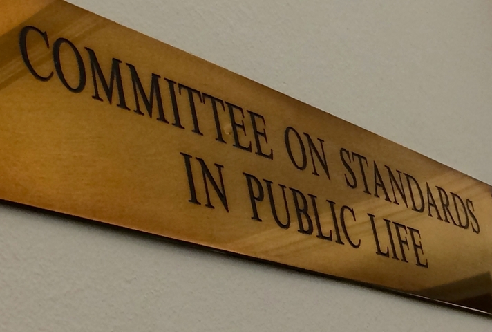 Медная табличка с надписью «Комитет по стандартам общественной жизни».
