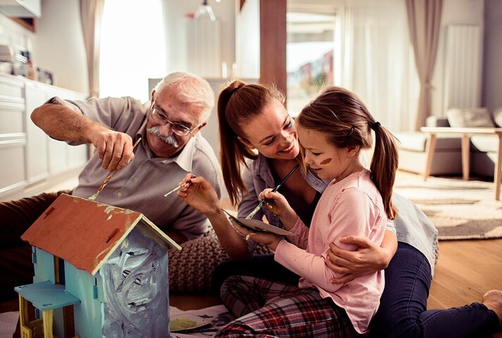 Stock image of a family painting a model house
