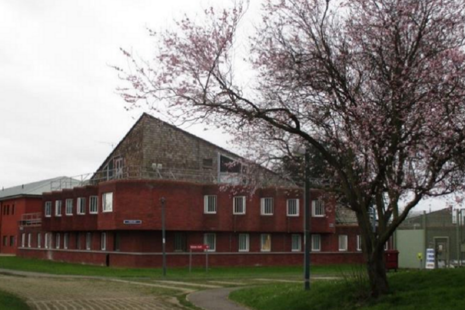 Photo of accommodation building exterior at Feltham, with a large tree in blossom in forefront
