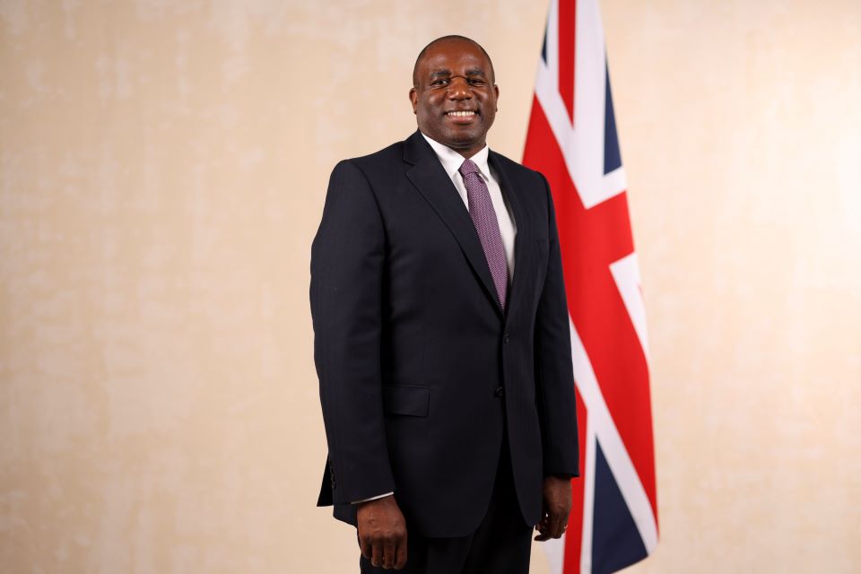 Image of the Foreign Secretary in front of the Union Jack 