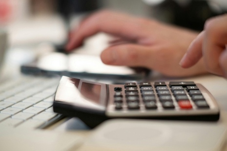 A person using a calculator and making notes