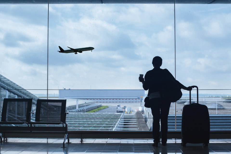 Passenger at airport watching plane take off