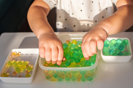 A child playing with water beads.