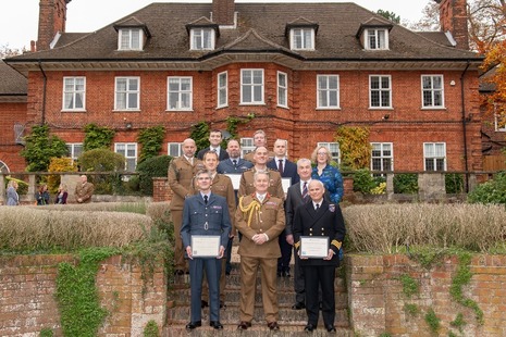 group photo outside a large house