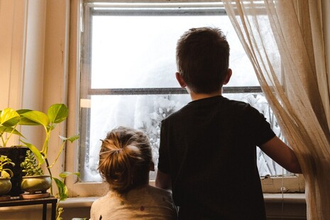 children looking out the window at snow