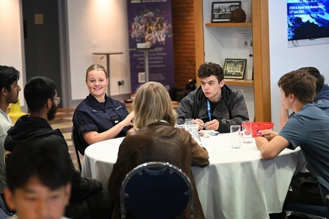 Students meeting Royal Navy personnel around a table