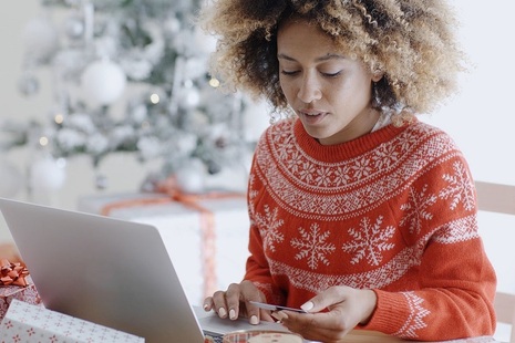 Person paying by card whilst using a laptop