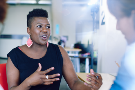 A woman speaking to two people