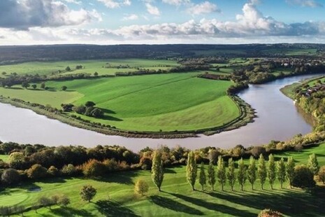 A river running through a green field.