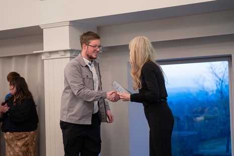student receiving a certificate from Claire Fry
