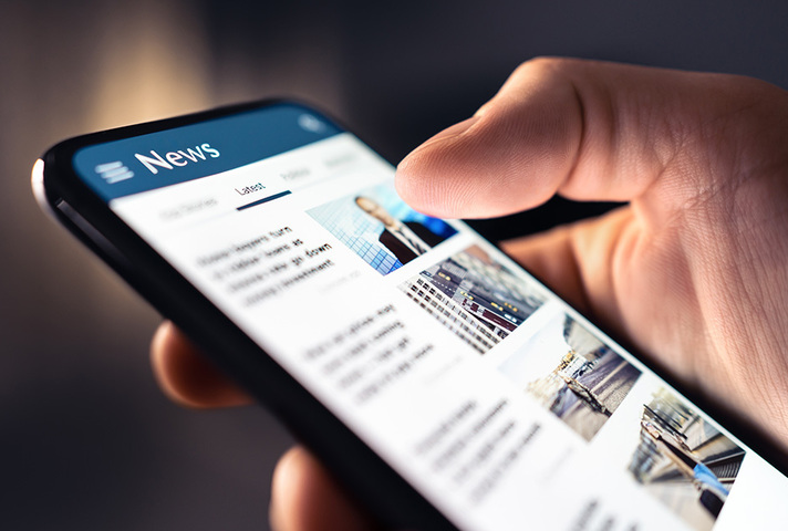 close up of smart phone, hand scrolling news stories