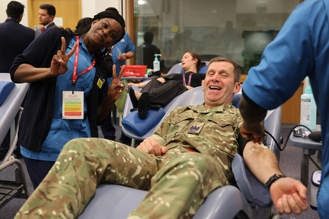 A man in uniform donating blood