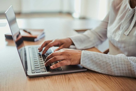 A person typing on a laptop computer