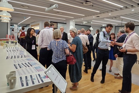 People standing and chatting in an interior setting. Credit: Crown copyright