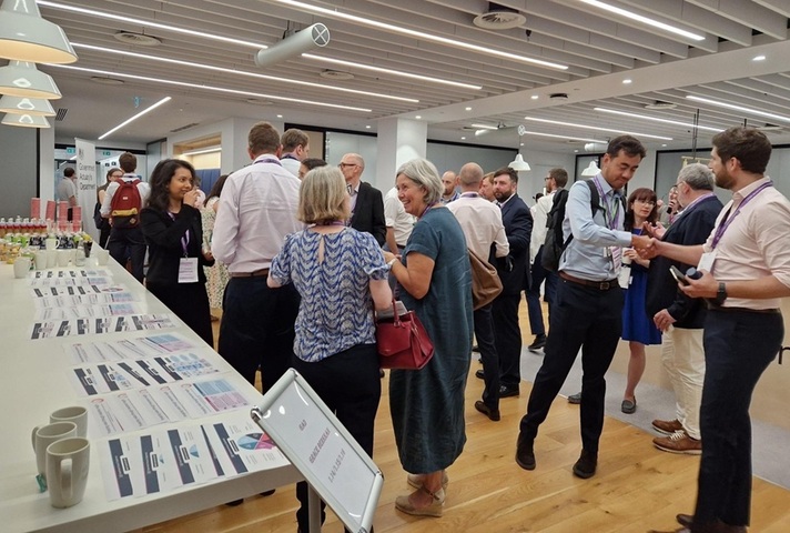 People standing and chatting in an interior setting. Credit: Crown copyright