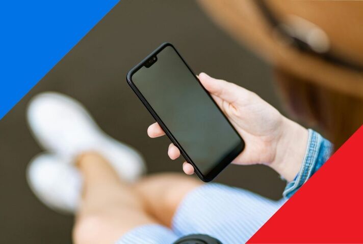 A person holds a smartphone. The image has blue and red triangular borders.