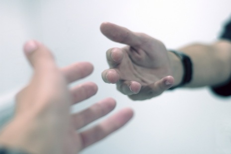 A patient reaching out their hand to a charity