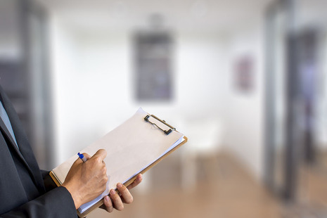 A person writing notes on a clipboard