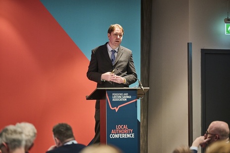 Man at a podium addressing conference delegates. Credit: Pensions UK
